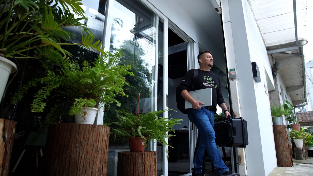 Enoc Burgos walking out of an office building with his portable Razer workstation