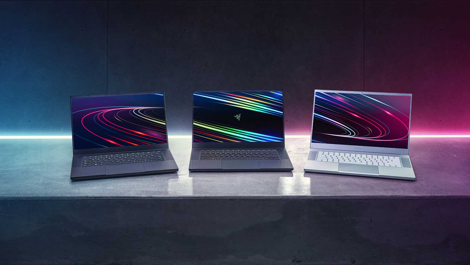 Three Razer Blade 15 laptops on a table, open and facing readers