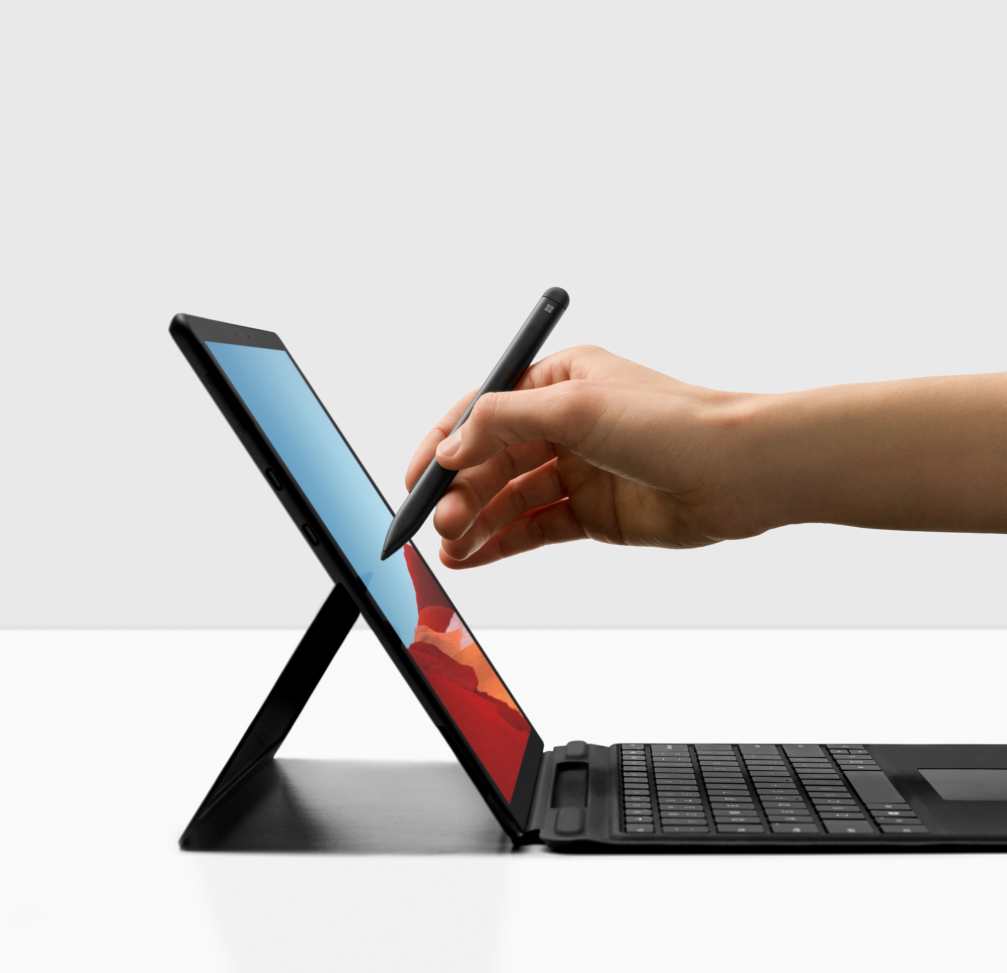 A hand using a pen on a Surface Pro X